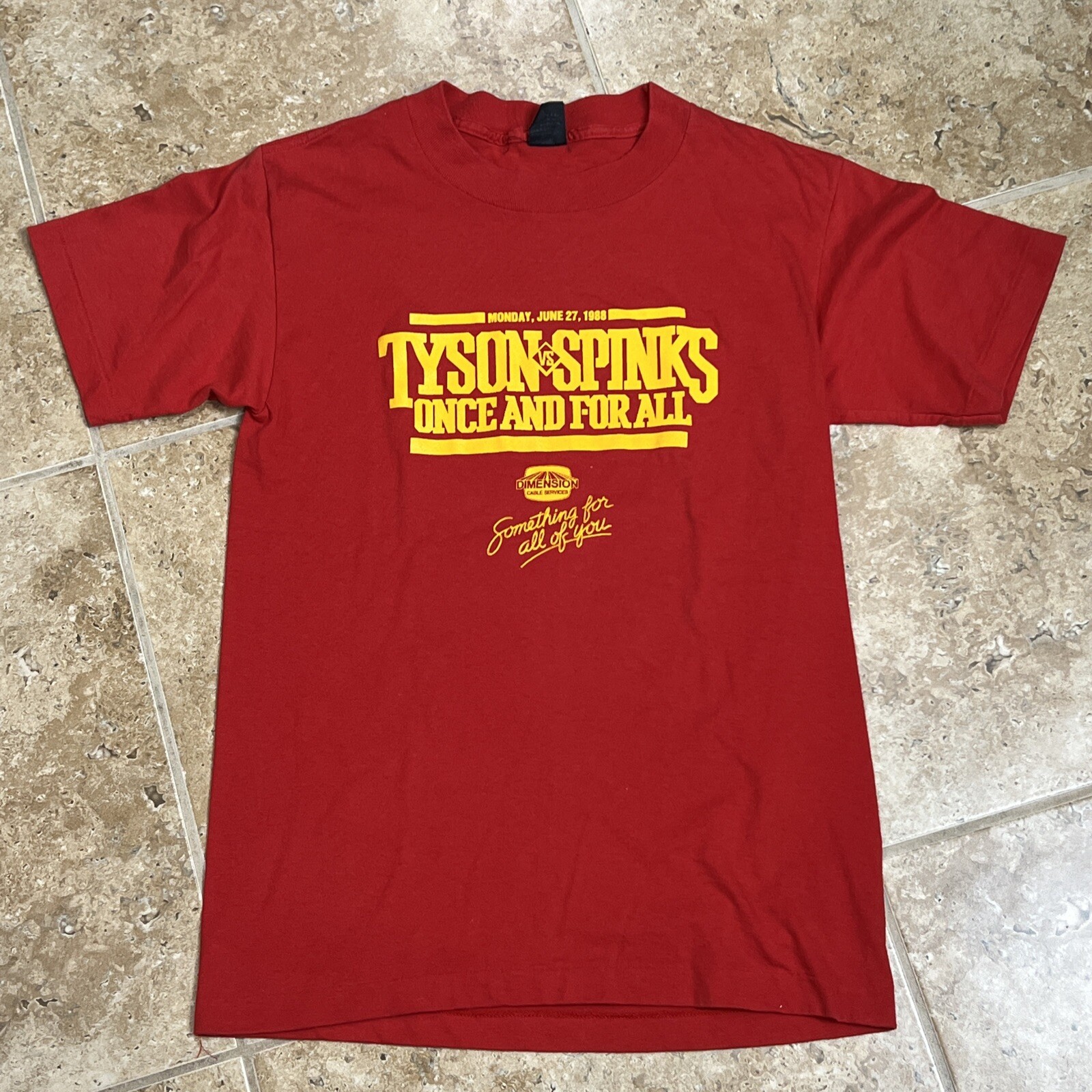 Front of a red 1988 Tyson vs Spinks t-shirt with a yellow Once and For All print and a Dimension Cable Services logo
